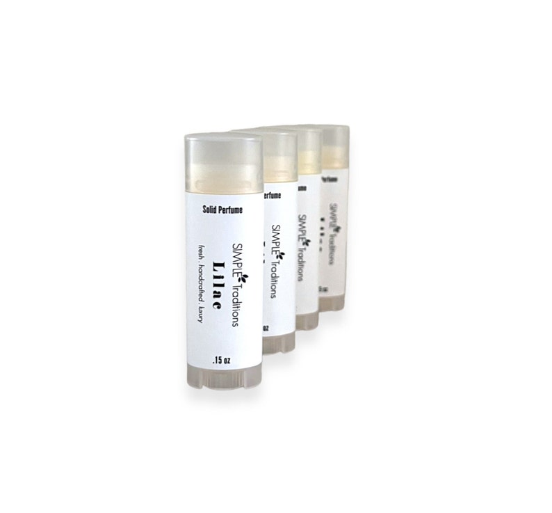 Pu&ograve; includere: Tre tubetti bianchi di profumo solido, ognuno etichettato con il testo "SIMPLE Traditions" e il nome del profumo. Il primo tubetto &egrave; etichettato "Lilac" e misura 0,15 oz.