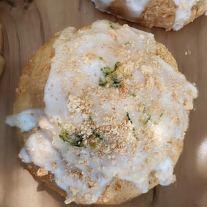 May include: White ceramic mug with a black handle, featuring the text "But First, Coffee" in black. The mug is displayed against a blurred backdrop, implying a comfortable environment.