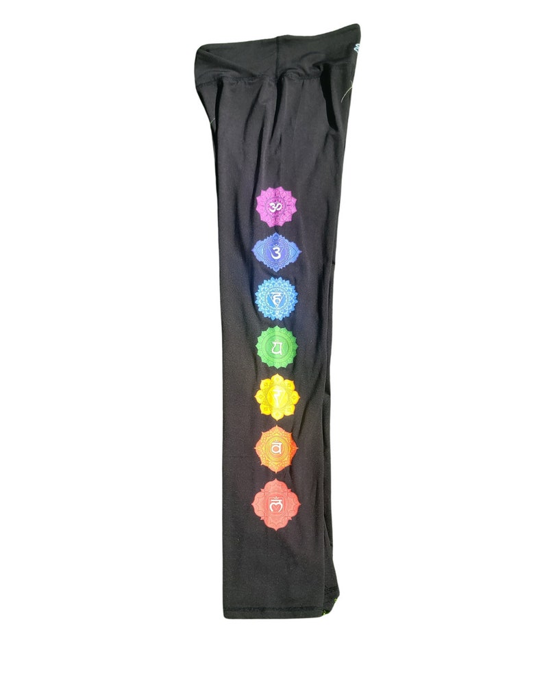 Puede incluir: Pantalones de yoga negros con un dise&ntilde;o de chakra colorido en la pierna izquierda. Los chakras est&aacute;n representados por s&iacute;mbolos y colores, incluyendo rojo, naranja, amarillo, verde, azul, &iacute;ndigo y violeta.