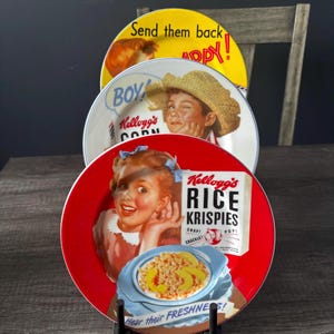 Peut inclure: Trois assiettes de céréales Kellogg's vintage. L'assiette supérieure est jaune avec du texte. L'assiette du milieu représente un garçon avec un chapeau de paille. L'assiette inférieure est rouge avec une fille et une boîte de Rice Krispies.