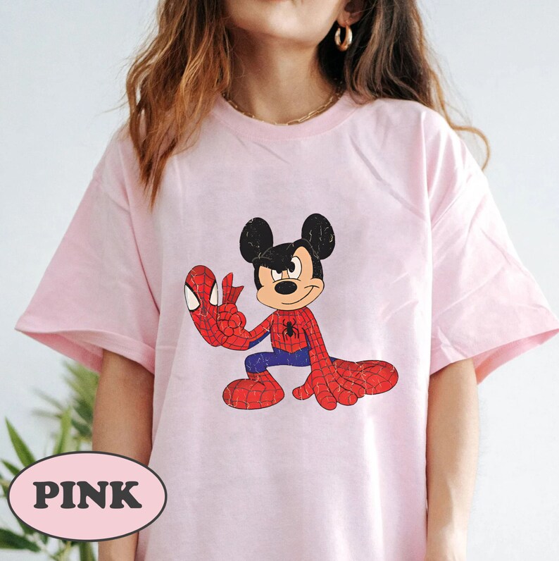 May include: Pink t-shirt with a cartoon image of Mickey Mouse dressed as Spider-Man.