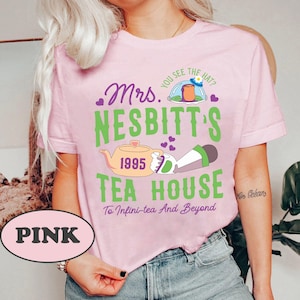 Peut inclure: T-shirt rose avec un motif graphique vert et violet qui dit "Mrs. Nesbitt's Tea House" avec une th&eacute;i&egrave;re et un personnage de dessin anim&eacute; tenant une tasse de th&eacute;. Le texte dit &eacute;galement "You see the hat?" et "To Infini-tea And Beyond".