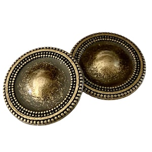 May include: Two antique gold-toned metal buttons with a raised, domed centre and a beaded border.