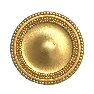 May include: A gold-coloured metal button with a raised, domed centre and a beaded border.