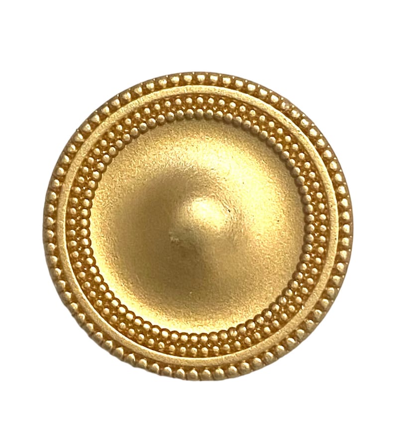 May include: A gold-coloured metal button with a raised, domed centre and a beaded border.