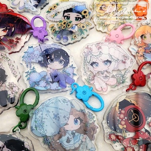 Può includere: Una collezione di ciondoli in acrilico in stile anime con vari personaggi a tema floreale e ombrello. Ogni ciondolo ha un design unico, colori vivaci e una chiusura abbinata. Ideali per borse o chiavi.