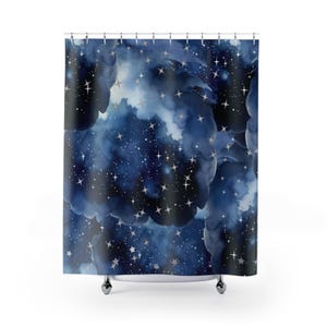May include: A shower curtain featuring a watercolor design of a night sky. The curtain has a dark blue background with white and silver stars, clouds, and nebulas. The design creates a celestial and dreamy atmosphere.