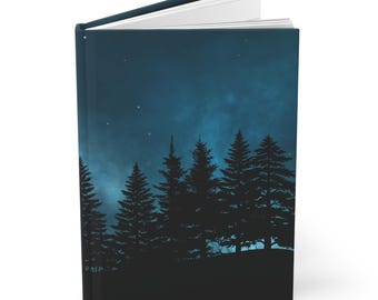 May include: A hardcover journal with a dark blue cover featuring a silhouette of a forest under a starry night sky. The open journal reveals white pages. The spine is dark blue.