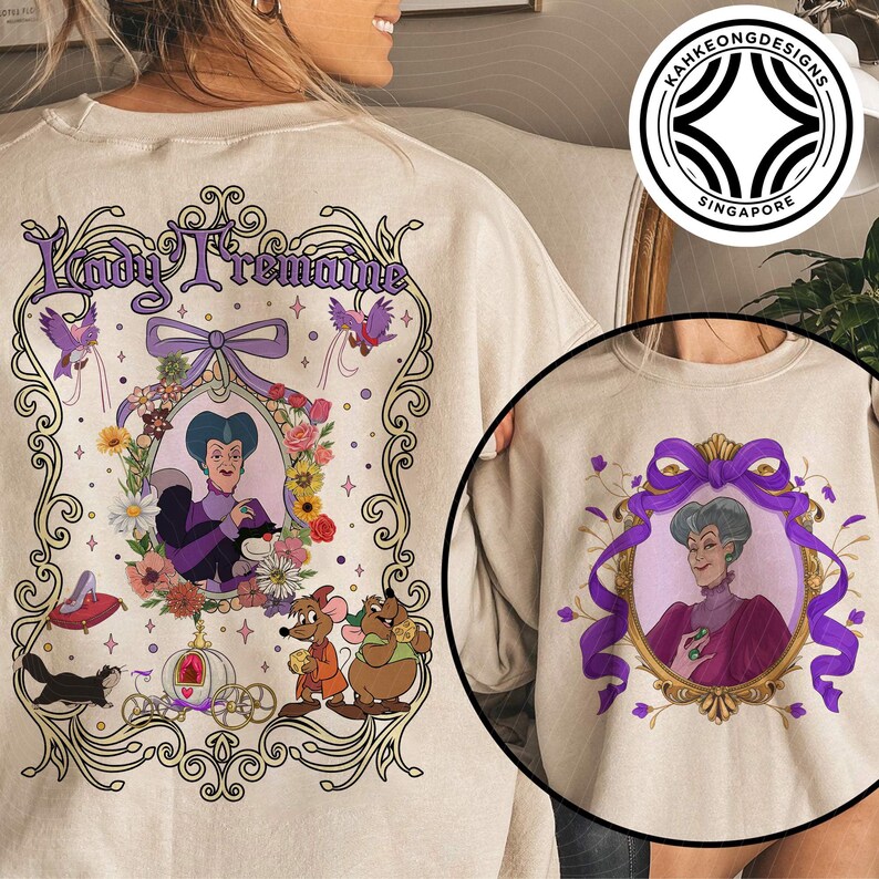 Puede incluir: Sudadera beige con una ilustraci&oacute;n enmarcada de Lady Tremaine. El dise&ntilde;o incluye un retrato, detalles florales y el texto "Lady Tremaine". Una versi&oacute;n m&aacute;s peque&ntilde;a del dise&ntilde;o est&aacute; en la manga.