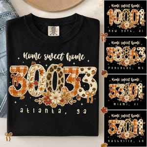 Könnte beinhalten: Ein schwarzes T-Shirt mit Rundhalsausschnitt und dem Text Home sweet home sowie Atlanta, GA. Die Grafik zeigt die Zahl 30033 in einer großen, dekorativen Schrift, gefüllt mit orangefarbenem Karomuster, Leopardenmuster und Herbstblumen.