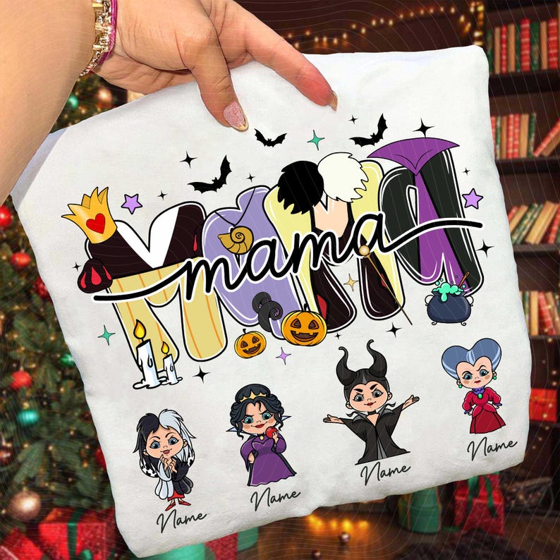 Peut inclure: Housse de coussin blanche avec le mot "Mama" dans une police de caract&egrave;res color&eacute;e et dessin&eacute;e, d&eacute;cor&eacute;e d'illustrations sur le th&egrave;me d'Halloween et des m&eacute;chants Disney. Comprend des images de citrouilles, de chauves-souris et de personnages.