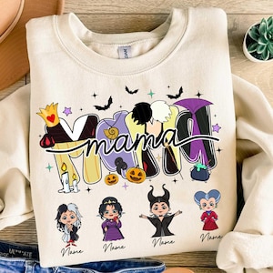 Peut inclure: Sweat-shirt cr&egrave;me avec le mot "mama" dans un design stylis&eacute; mettant en vedette des m&eacute;chants Disney. Les lettres sont d&eacute;cor&eacute;es d'images d'une couronne, d'un coquillage, d'une perruque noire et d'une cape violette. En dessous, quatre personnages de m&eacute;chants de dessins anim&eacute;s.