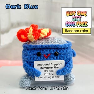 May include: A dark blue crocheted "Emotional Support Dumpster Fire" toy with a red and yellow top. The toy has black eyes and a red beak. A small white card reads "It's fine, I'm fine, Everything is fine!" The toy measures 1.97" x 2.76".