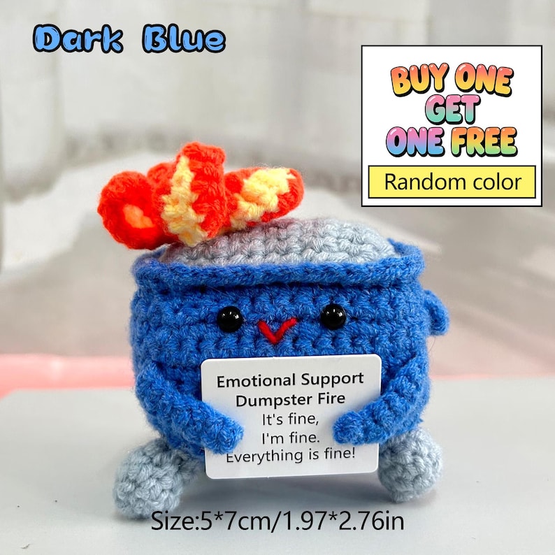 May include: A dark blue crocheted "Emotional Support Dumpster Fire" toy with a red and yellow top. The toy has black eyes and a red beak. A small white card reads "It's fine, I'm fine, Everything is fine!" The toy measures 1.97" x 2.76".
