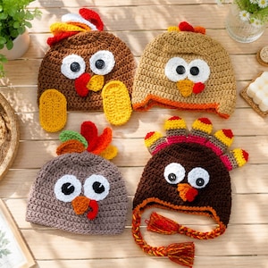 May include: Four crocheted hats designed to resemble turkeys. Each hat features large white eyes with black button pupils, a yellow or orange beak, and a red wattle. The hats are crafted in brown, tan, and gray yarn with colorful feather accents.