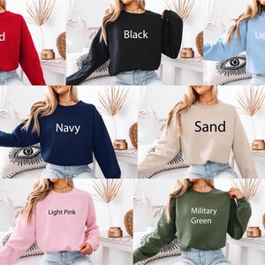 May include: A collection of eleven long-sleeved crewneck sweatshirts shown in various colors including red, black, light blue, white, navy, sand, athletic heather, forest green, light pink, military green, and maroon, each labeled with its color name.