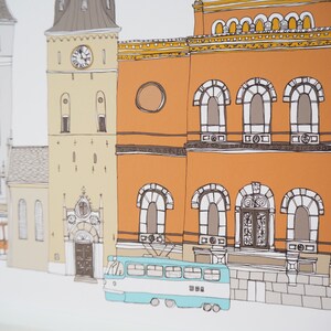 Pu&ograve; includere: Un'illustrazione colorata di una scena di strada cittadina con edifici, un tram e una torre dell'orologio. Gli edifici sono disegnati in stile cartone animato con colori arancio, giallo e marrone. Il tram &egrave; blu e bianco e ha una parte anteriore arrotondata. La torre dell'orologio &egrave; alta e ha un tetto a punta.