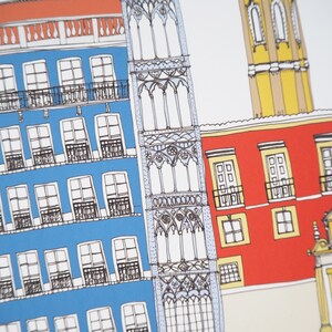 May include: A hand-drawn illustration of a colorful cityscape with buildings in shades of red, yellow, blue, and white. The buildings have windows and balconies, and there is a tall tower in the background.