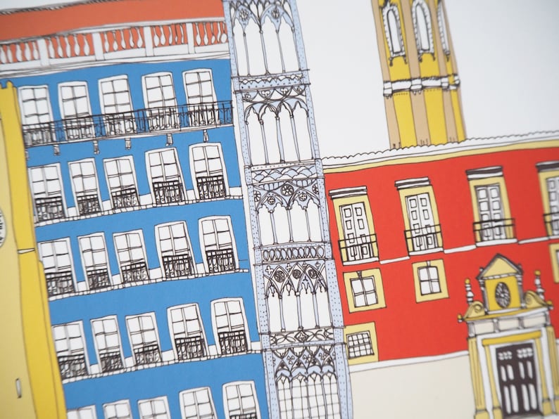 May include: A hand-drawn illustration of a colorful cityscape with buildings in shades of red, yellow, blue, and white. The buildings have windows and balconies, and there is a tall tower in the background.