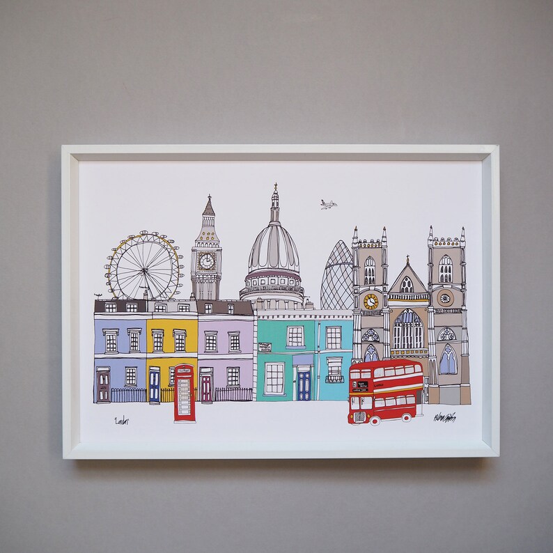 Puede incluir: Una ilustraci&oacute;n colorida de monumentos de Londres, incluyendo el Big Ben, el London Eye y un autob&uacute;s de dos pisos rojo. La ilustraci&oacute;n est&aacute; enmarcada en un marco blanco e incluye la palabra "Londres" en la parte inferior.