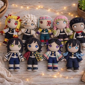 May include: A collection of nine handmade crochet dolls with detailed features. Each doll has unique hair and clothing, with vibrant colors like yellow, pink, and blue. The dolls are arranged on a wooden surface with decorative lights.