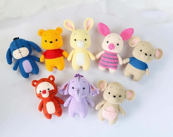 May include: A collection of nine crocheted stuffed animals, including Winnie the Pooh, Piglet, Eeyore, Tigger, and a bunny. The animals are all different colors and have different facial expressions.