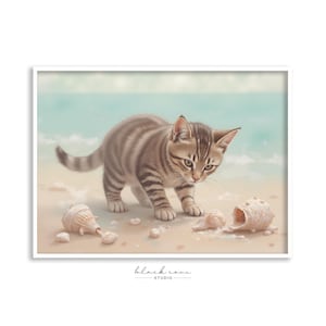 May include: A watercolor painting of a tabby kitten on a sandy beach, with seashells scattered around. The kitten is brown and gray, with its head down, looking at the shells. The background features a light blue sky and ocean.