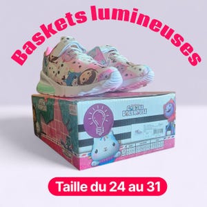 May include: Pair of light-up sneakers featuring a colorful Gabby's Dollhouse design, set atop a matching box. The shoes have pink, blue, and white accents. The box displays the text "GABBY'S DOLLHOUSE" and a lightbulb graphic.