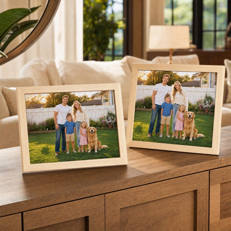 Puede incluir: Dos marcos de fotos rectangulares de madera clara expuestos uno al lado del otro. Cada marco contiene una fotograf&iacute;a de una familia compuesta por dos adultos, dos ni&ntilde;os y un golden retriever de pie sobre un c&eacute;sped verde frente a una valla blanca.