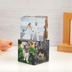 Op de afbeelding: Twee houten fotoblokken op elkaar gestapeld. De bovenste kubus toont een trouwfoto, de onderste kubus een hond en een kat. Een unieke manier om dierbare herinneringen te tonen. Elke kubus is ongeveer 7 cm.