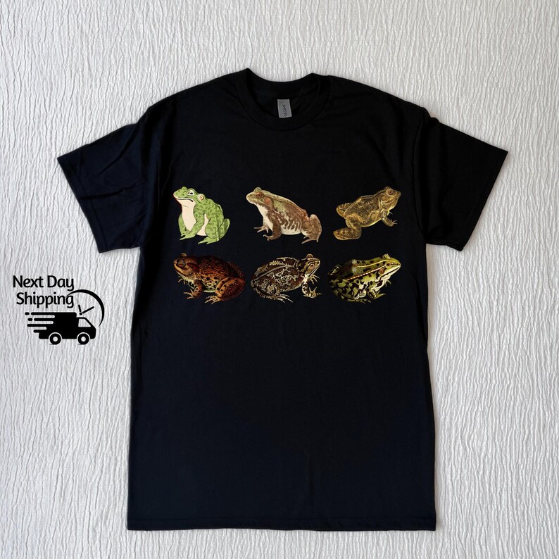 May include: Black t-shirt with a graphic print of six different frogs in various poses. The frogs are green, brown, and tan.