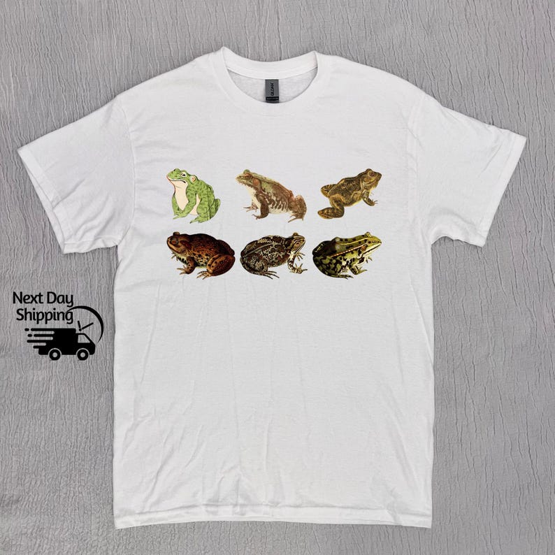 May include: White t-shirt with a graphic of six different frogs in various poses. The frogs are brown, green, and tan.