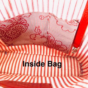 May include: Inside view of a red bag with a striped lining. The lining has red and white stripes and a patterned pocket. The text "Inside Bag" is visible in the centre of the image.