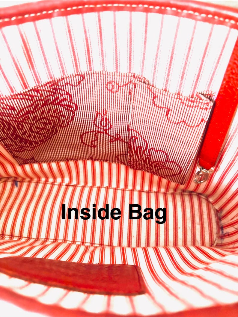 May include: Inside view of a red bag with a striped lining. The lining has red and white stripes and a patterned pocket. The text "Inside Bag" is visible in the centre of the image.