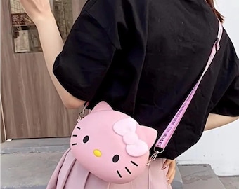 ハローキティ クロスボディバッグ シリコン製 フレキシブルなピンクのフェイスと赤いリボンのピンクのストラップ