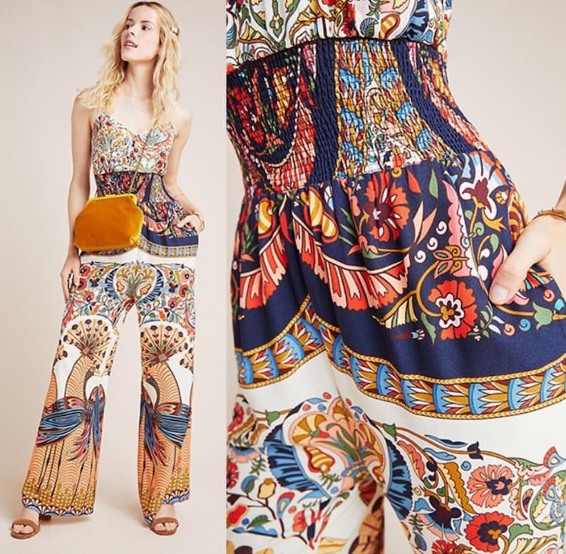 May include: A white and blue patterned jumpsuit with a floral design. The jumpsuit has a smocked waist and wide legs.