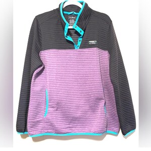May include: A black and purple pullover with a ribbed texture. The top portion is black, and the lower section is purple. It features a teal collar, buttons, and trim. The L.L.Bean logo is visible on the chest.