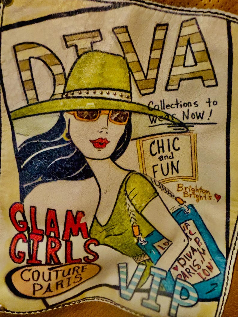 May include: A rectangular leather patch featuring a hand-painted illustration of a person in a wide-brimmed hat and sunglasses. Text includes DIVA, Collections to Wear Now!, CHIC and FUN, Brighton Brights, GLAM GIRLS, COUTURE PARIS, and VIP.