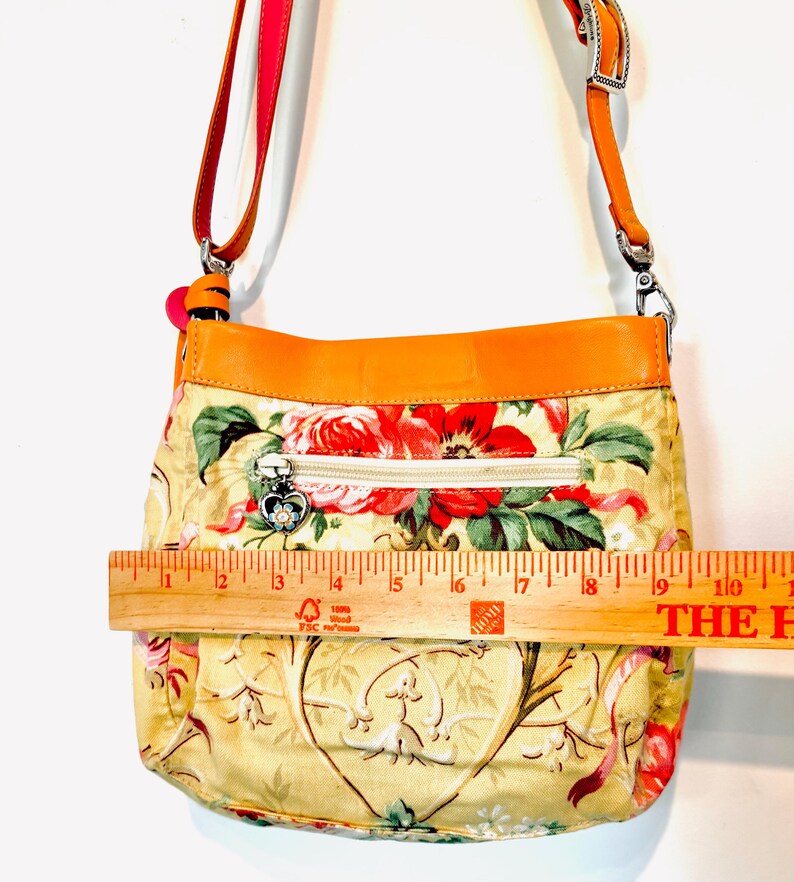 以下が含まれることがあります： 白いセラミックマグカップ、黒いハンドル、手書き風の「But First, Coffee」の文字。マグカップは白い面に置かれています。マグカップの高さは約10cmです。