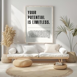 Könnte beinhalten: Ein gerahmter Druck mit dem Text "YOUR POTENTIAL IS LIMITLESS" in fetten schwarzen Buchstaben. Der Druck hängt über einem hellen Holzsofa mit weißen Kissen. Ein gewebter Teppich und dekorative Pflanzen vervollständigen die Raumdekoration.