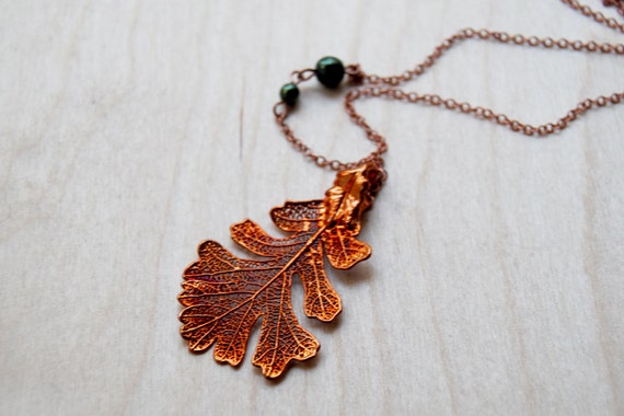 A real oak leaf coated in actual copper via electroforming — nature preserved as wearable sculpture, no two are ever identical.