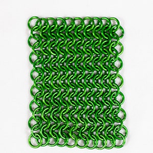 Puede incluir: Una malla de cota de malla de metal verde, hecha de peque&ntilde;os anillos entrelazados.