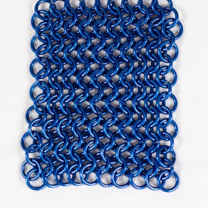Puede incluir: Una malla de cota de malla de metal azul, hecha de anillos entrelazados.