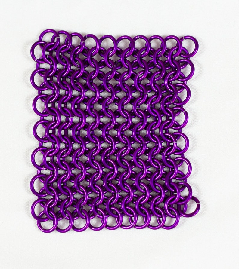 Puede incluir: Un cuadrado de cota de malla p&uacute;rpura hecho de peque&ntilde;os anillos de metal.