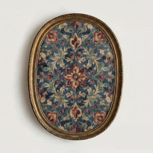 May include: An oval-shaped framed artwork with a gold-colored ornate frame. The artwork features a floral pattern in shades of blue, green, red, and yellow. The design is symmetrical, with a central flower and surrounding foliage.