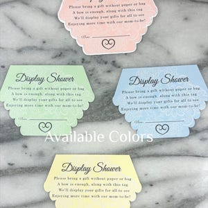 May include: Four pastel-coloured display shower cards with scalloped edges. Each card features the text "Display Shower" and instructions for gift-giving. Available colours include pink, green, blue, and yellow. A heart design is at the bottom.