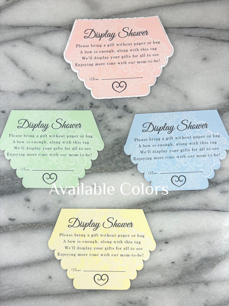 May include: Four pastel-coloured display shower cards with scalloped edges. Each card features the text "Display Shower" and instructions for gift-giving. Available colours include pink, green, blue, and yellow. A heart design is at the bottom.