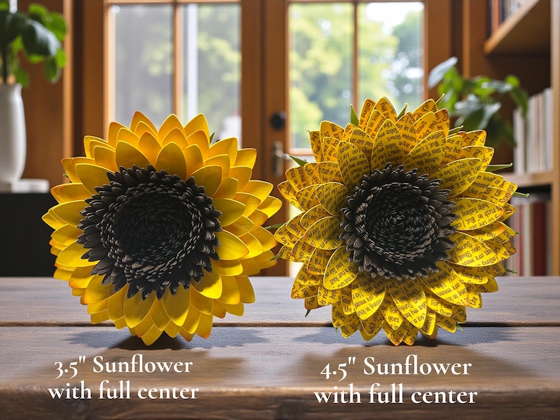 May include: Two paper sunflowers with full centers are displayed on a wooden surface. The sunflower on the left is 3.5 inches in diameter, and the one on the right is 4.5 inches. Both have yellow petals and dark centers.