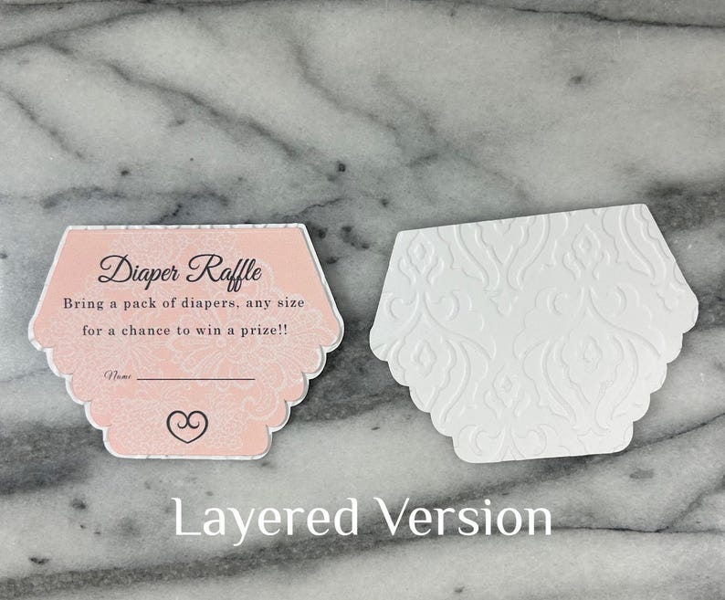 May include: Two hexagonal baby shower raffle cards. One is pink with the text "Diaper Raffle" and details. The other is white with a floral embossed design. The words "Layered Version" are at the bottom.
