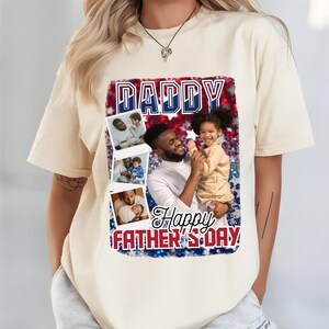 Peut inclure: T-shirt cr&egrave;me avec un motif pour la f&ecirc;te des p&egrave;res. Le motif comprend le mot "DADDY" en bleu et blanc, les mots "Happy FATHER'S DAY" en rouge et blanc, et plusieurs petites photos d'un p&egrave;re et d'un enfant.